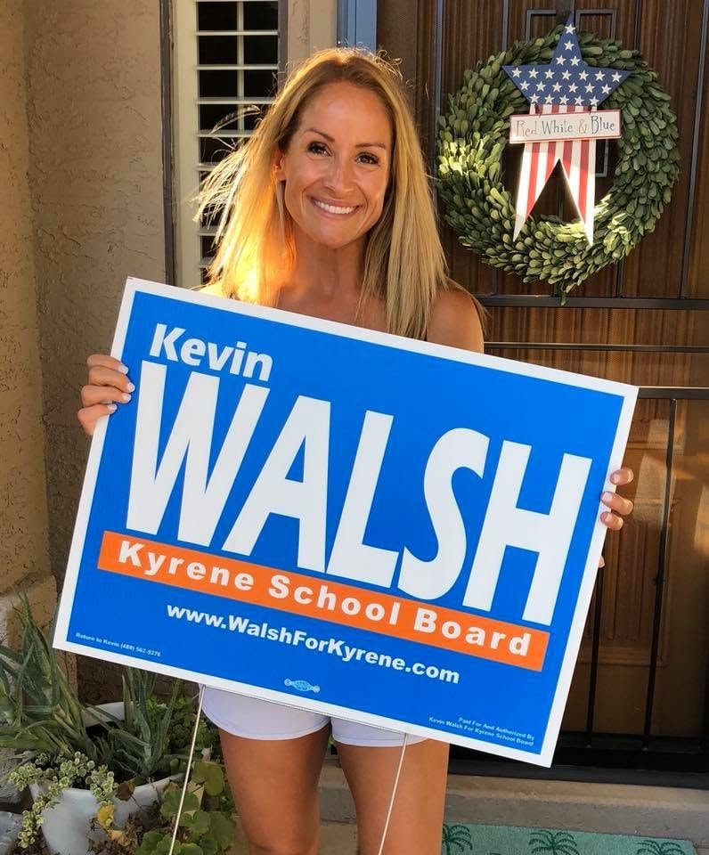 Kevin's spouse holding a campaign sign