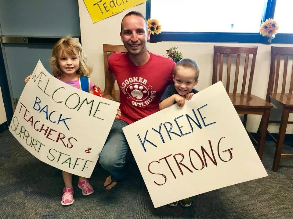 Kevin and kids holding Kyrene Strong signs
